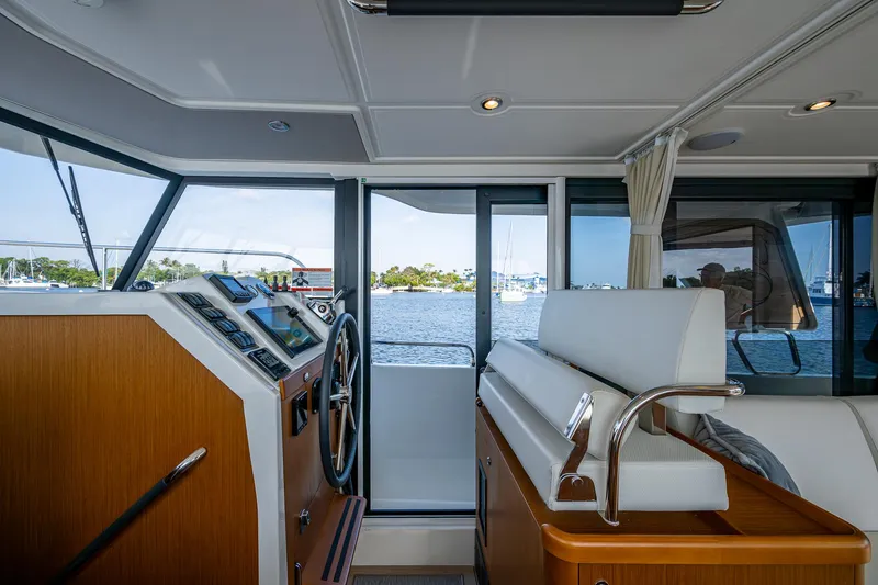 Ashokan Yacht Photos Pics Interior view of 2022 Beneteau Swift Trawler 35 helm with scenic water backdrop.