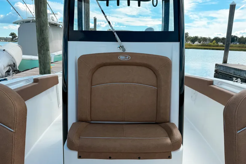  Yacht Photos Pics 2023 Sea Hunt Ultra 275 SE boat interior with brown seating, docked by the water.