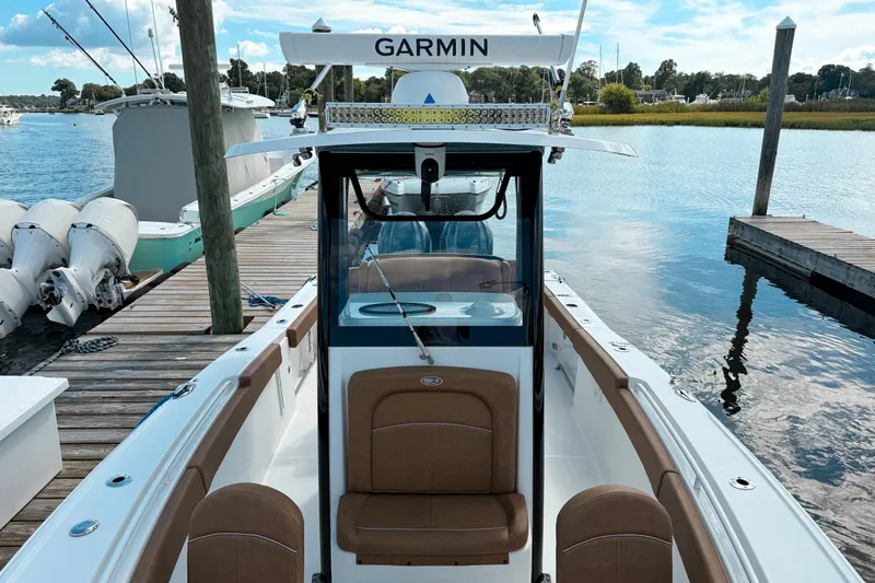  Yacht Photos Pics 2023 Sea Hunt Ultra 275 SE boat docked, featuring Garmin equipment, calm water background.