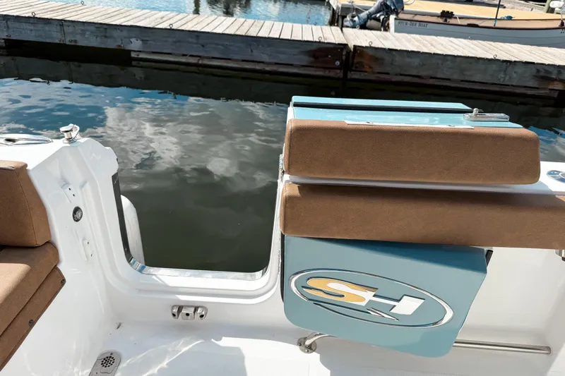  Yacht Photos Pics 2023 Sea Hunt Ultra 275 SE boat interior with cushioned seating and open transom door.