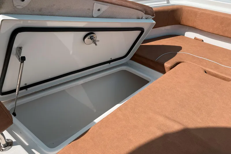  Yacht Photos Pics Open storage compartment on 2023 Sea Hunt Ultra 275 SE boat with brown seating.