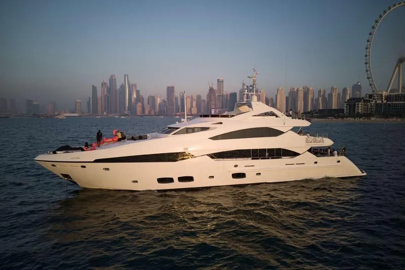  Yacht Photos Pics Luxurious 2010 Sunseeker 131 Yacht cruising near a city skyline at sunset.