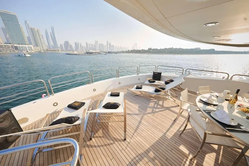  Yacht Photos Pics Luxurious Sunseeker 131 Yacht deck with city skyline view, featuring elegant dining setup.