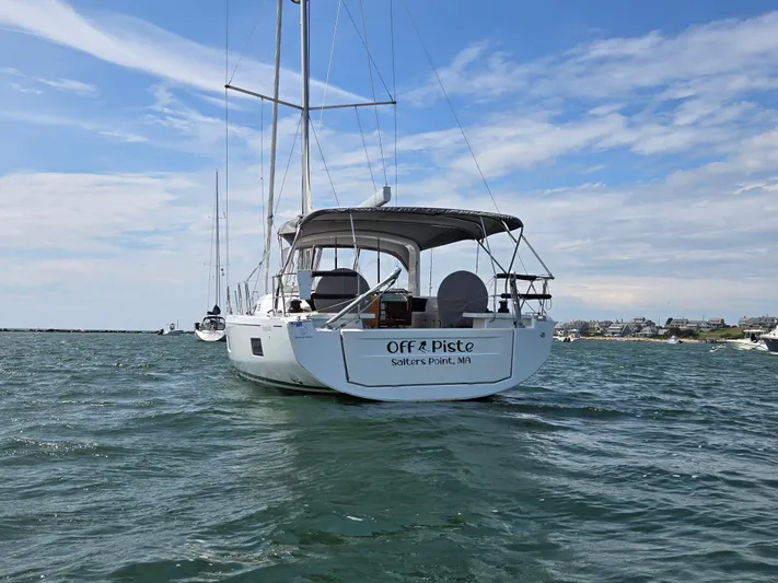 Off-piste Yacht Photos Pics 2019 Beneteau Oceanis 46.1 sailboat anchored in scenic coastal waters.