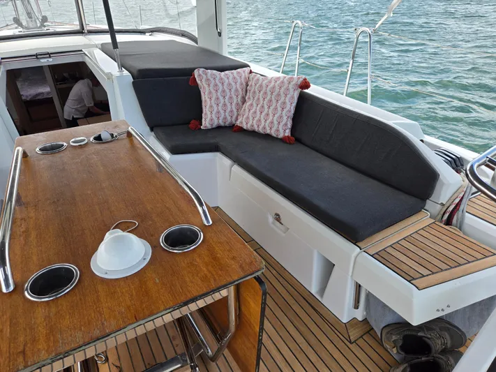 Off-piste Yacht Photos Pics 2019 Beneteau Oceanis 46.1 yacht cockpit with wooden table and cushioned seating.