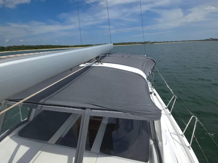 Off-piste Yacht Photos Pics 2019 Beneteau Oceanis 46.1 sailboat on calm waters under a clear blue sky.