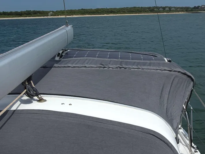 Off-piste Yacht Photos Pics 2019 Beneteau Oceanis 46.1 sailboat with solar panel, sailing near a coastline.
