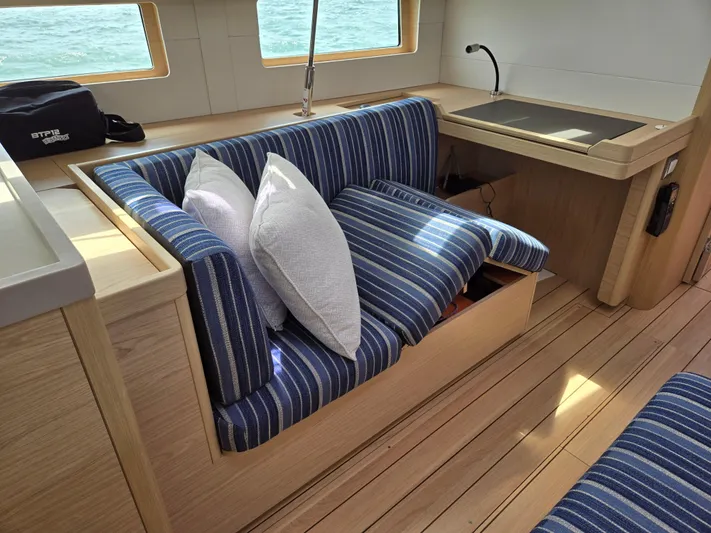 Off-piste Yacht Photos Pics Interior of 2019 Beneteau Oceanis 46.1 yacht with striped seating and wooden flooring.