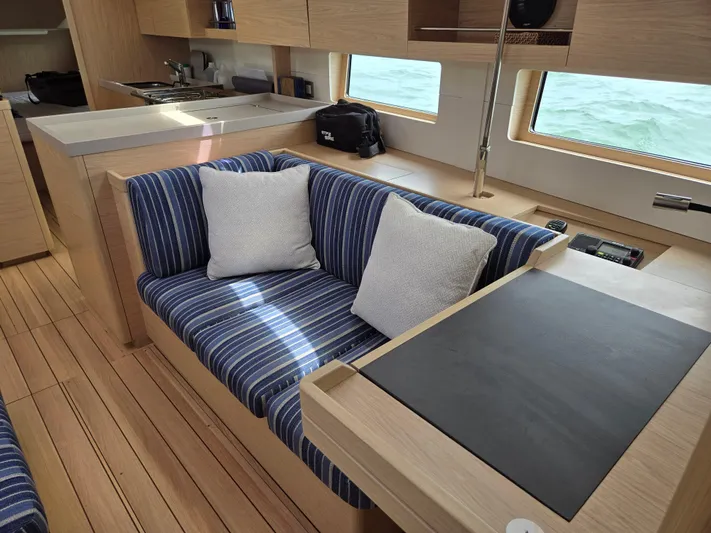 Off-piste Yacht Photos Pics Interior of 2019 Beneteau Oceanis 46.1 yacht with striped seating and modern kitchen.
