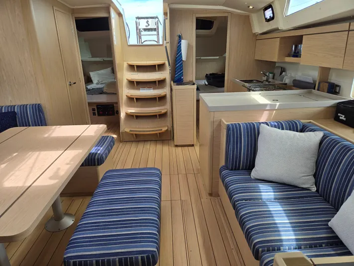 Off-piste Yacht Photos Pics Interior of 2019 Beneteau Oceanis 46.1 yacht with modern wood finish and striped seating.