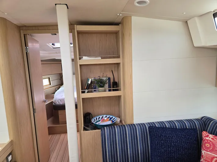 Off-piste Yacht Photos Pics Interior of 2019 Beneteau Oceanis 46.1 yacht, featuring cozy cabin and wooden shelving.