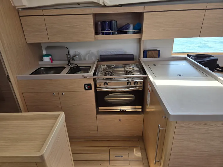 Off-piste Yacht Photos Pics Modern kitchen in 2019 Beneteau Oceanis 46.1 yacht with stove, sink, and storage.