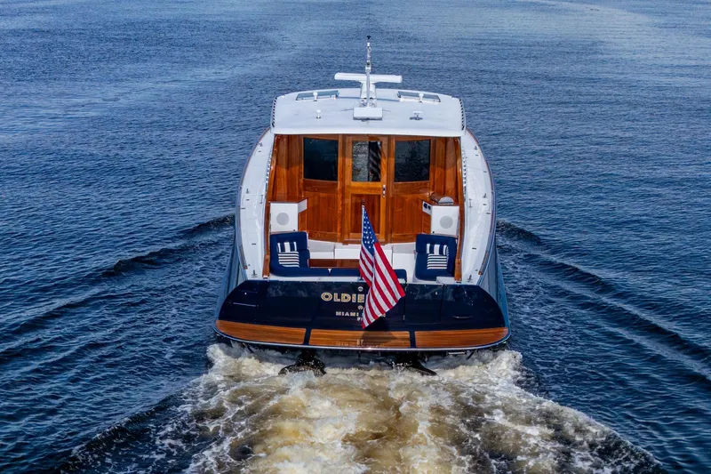 Oldielox 2 Yacht Photos Pics Hinckley T55 MKII Motor Yacht 2019 cruising on open water, rear view with American flag.