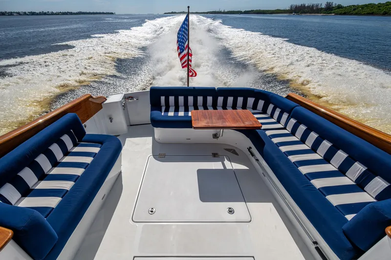 Oldielox 2 Yacht Photos Pics Hinckley T55 MKII Motor Yacht 2019, elegant deck with striped seating and American flag.