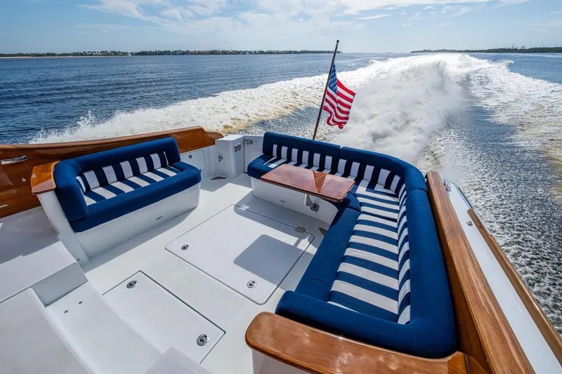 Oldielox 2 Yacht Photos Pics Hinckley T55 MKII Motor Yacht 2019, elegant deck with striped seating, American flag, ocean view.