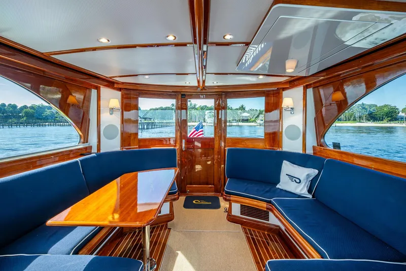 Oldielox 2 Yacht Photos Pics Luxurious interior of 2019 Hinckley T55 MKII Motor Yacht with elegant wood finish and blue seating.