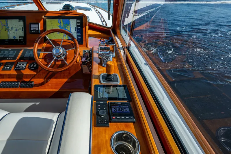 Oldielox 2 Yacht Photos Pics Helm of 2019 Hinckley T55 MKII Motor Yacht with navigation screens and wooden steering wheel.