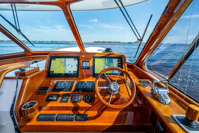 Oldielox 2 Yacht Photos Pics Helm of 2019 Hinckley T55 MKII Motor Yacht with navigation screens and wooden steering wheel.
