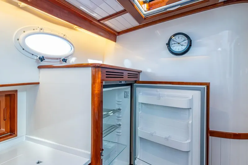 Oldielox 2 Yacht Photos Pics Interior of 2019 Hinckley T55 MKII Motor Yacht with open fridge and porthole window.