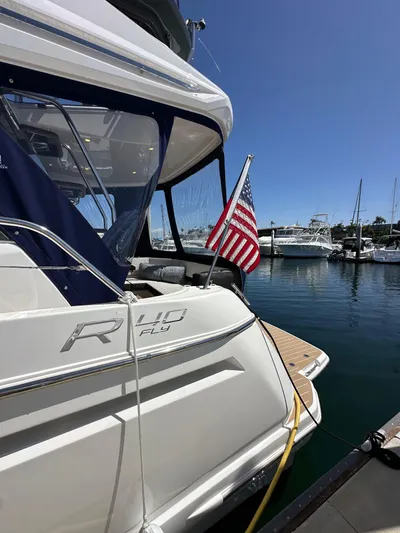  Yacht Photos Pics 2024 Bavaria R40 yacht docked with American flag, sunny marina background.