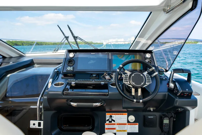  Yacht Photos Pics 2024 Jeanneau DB/43 OB helm with advanced navigation system and steering wheel, overlooking the ocean.