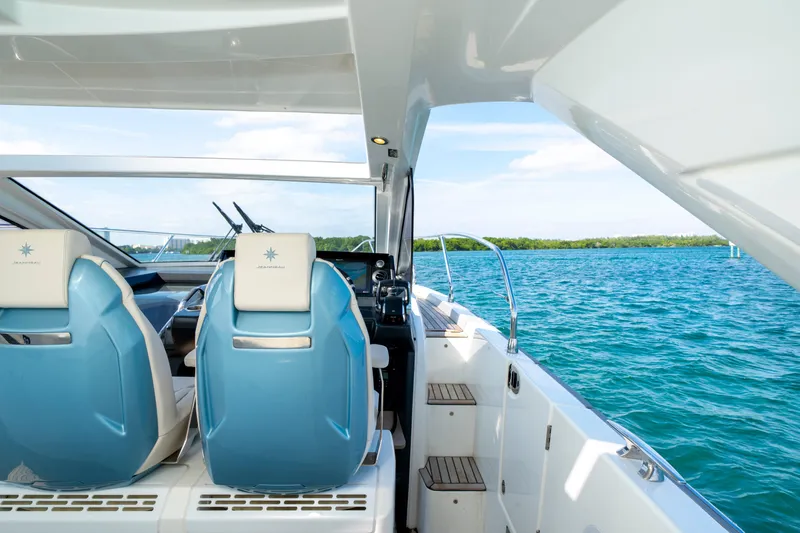  Yacht Photos Pics 2024 Jeanneau DB/43 OB boat interior with blue seats, overlooking serene water.