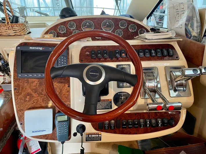 Seaduced Yacht Photos Pics 2006 Meridian 341 Sedan helm with wood accents and navigation controls.