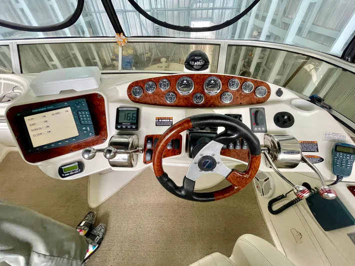 Seaduced Yacht Photos Pics 2006 Meridian 341 Sedan helm with wood accents and modern navigation controls.