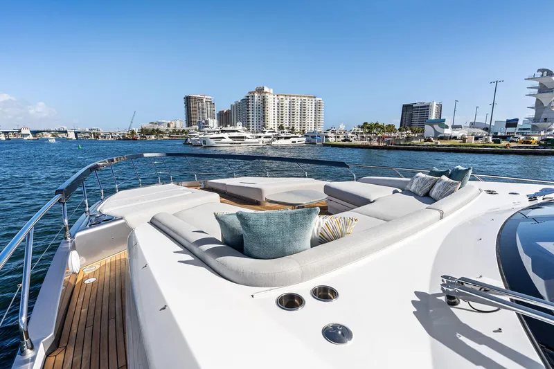 Yesenia Yacht Photos Pics Luxurious 2024 Azimut S8 yacht deck with plush seating, overlooking a marina and cityscape.