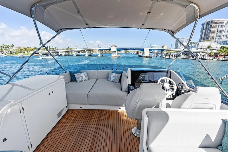 Yesenia Yacht Photos Pics 2024 Azimut S8 yacht interior with seating and helm, overlooking a scenic waterfront.