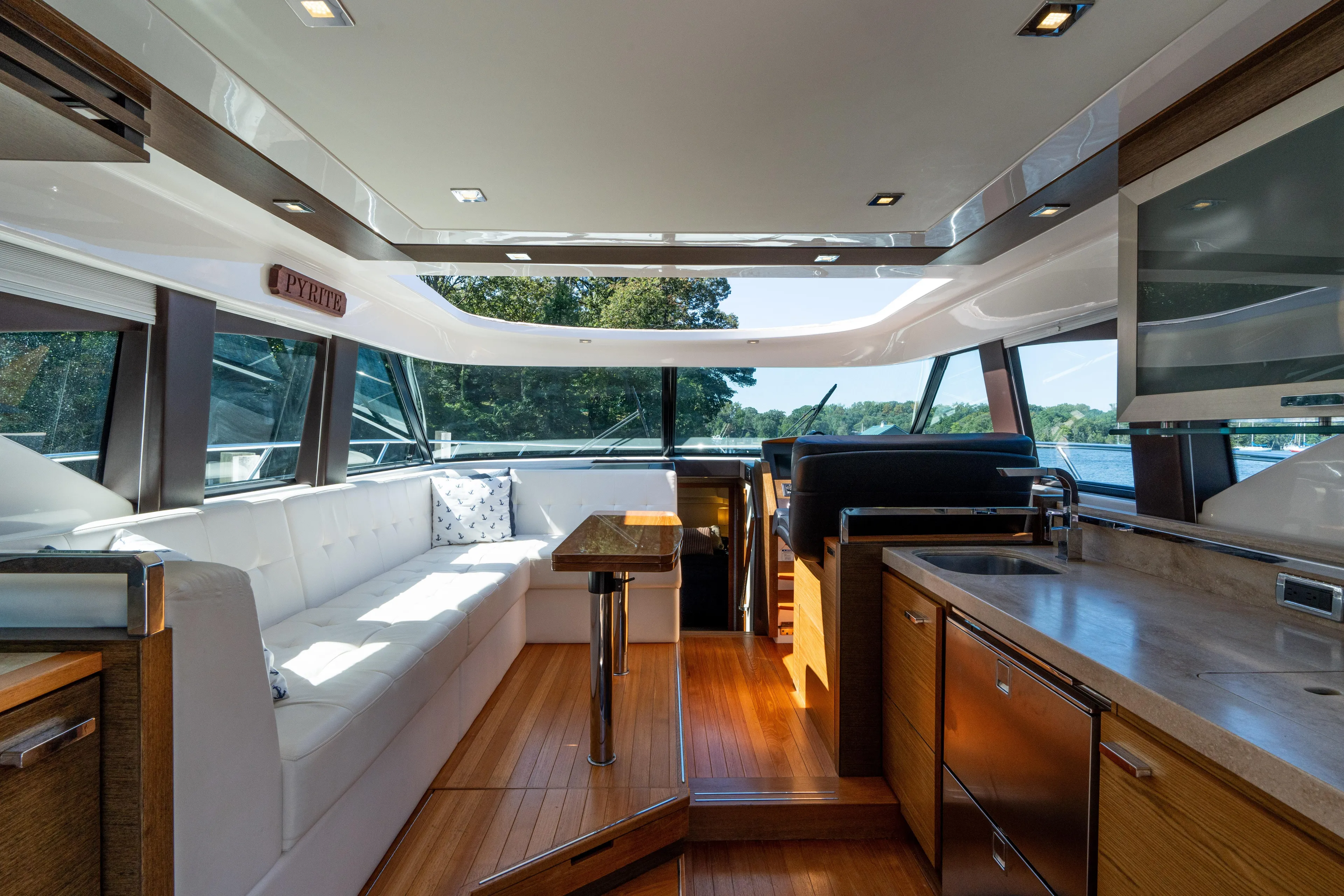 Pyrite Yacht Photos Pics Luxurious interior of 2015 Tiara Yachts C44 Coupe with modern seating and kitchen area.