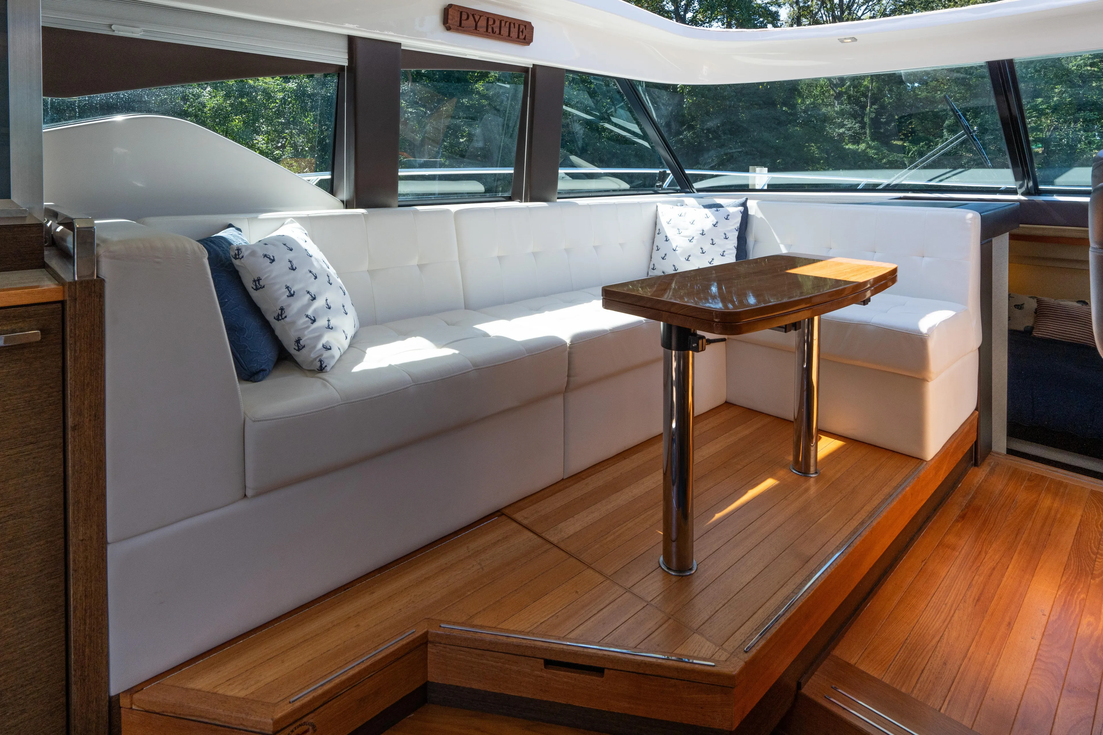 Pyrite Yacht Photos Pics Luxurious interior of 2015 Tiara Yachts C44 Coupe with white seating and wooden table.