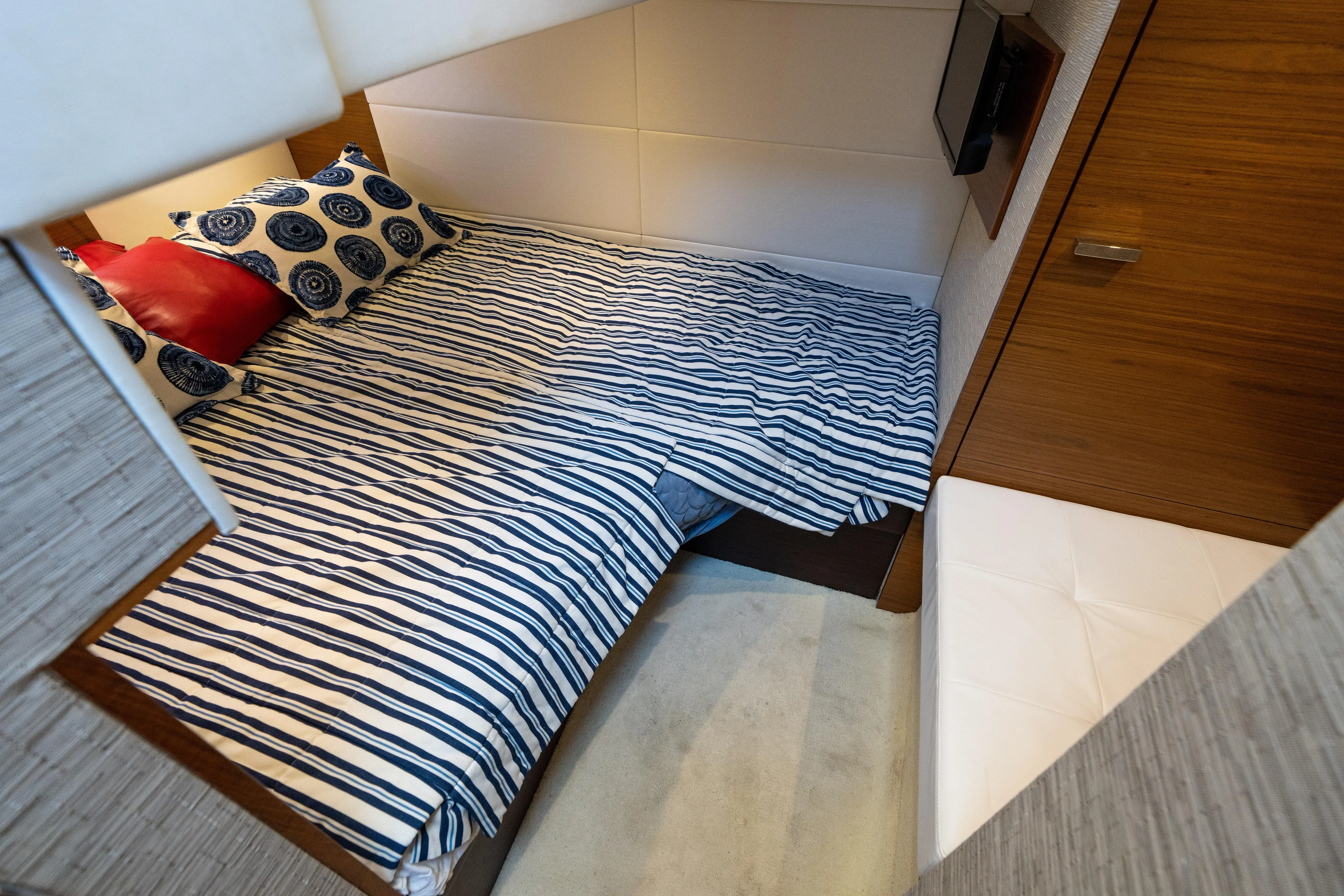 Pyrite Yacht Photos Pics Cozy cabin interior of 2015 Tiara Yachts C44 Coupe with striped bedding and wooden accents.