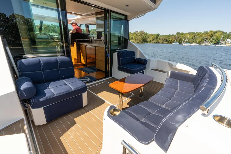 Pyrite Yacht Photos Pics 2015 Tiara Yachts C44 Coupe with luxurious seating on deck, overlooking serene waters.