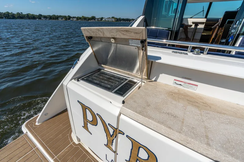 Pyrite Yacht Photos Pics Outdoor grill on 2015 Tiara Yachts C44 Coupe, docked by a scenic waterfront.