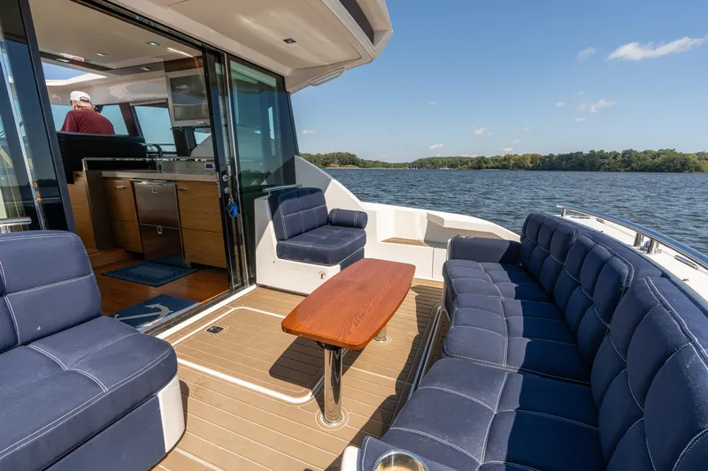 Pyrite Yacht Photos Pics 2015 Tiara Yachts C44 Coupe interior with blue seating, wooden table, and scenic water view.