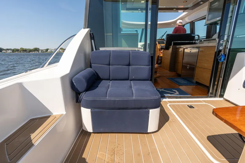 Pyrite Yacht Photos Pics 2015 Tiara Yachts C44 Coupe interior with blue seating and wooden flooring.