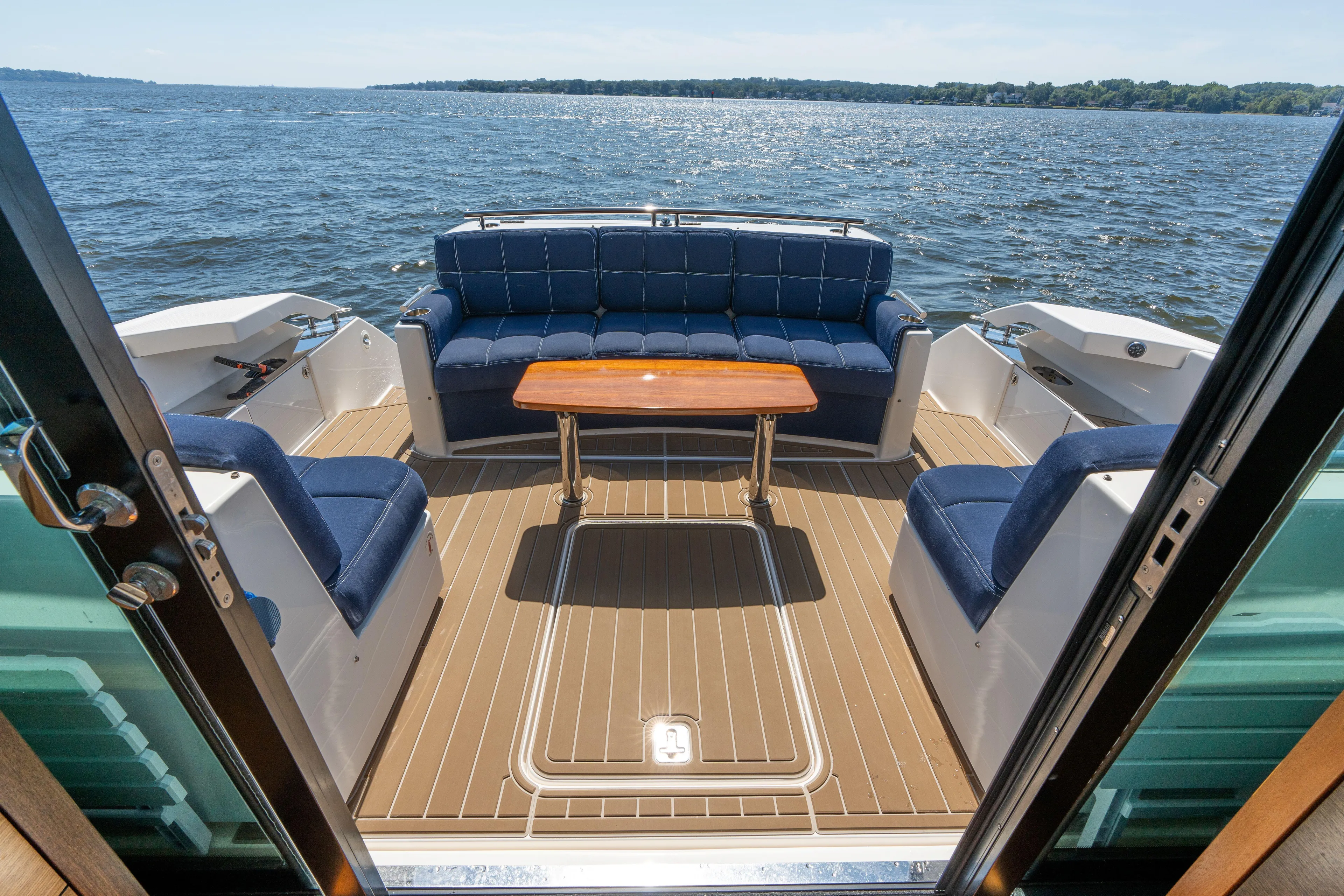 Pyrite Yacht Photos Pics Luxurious 2015 Tiara Yachts C44 Coupe deck with seating and table, overlooking serene waters.