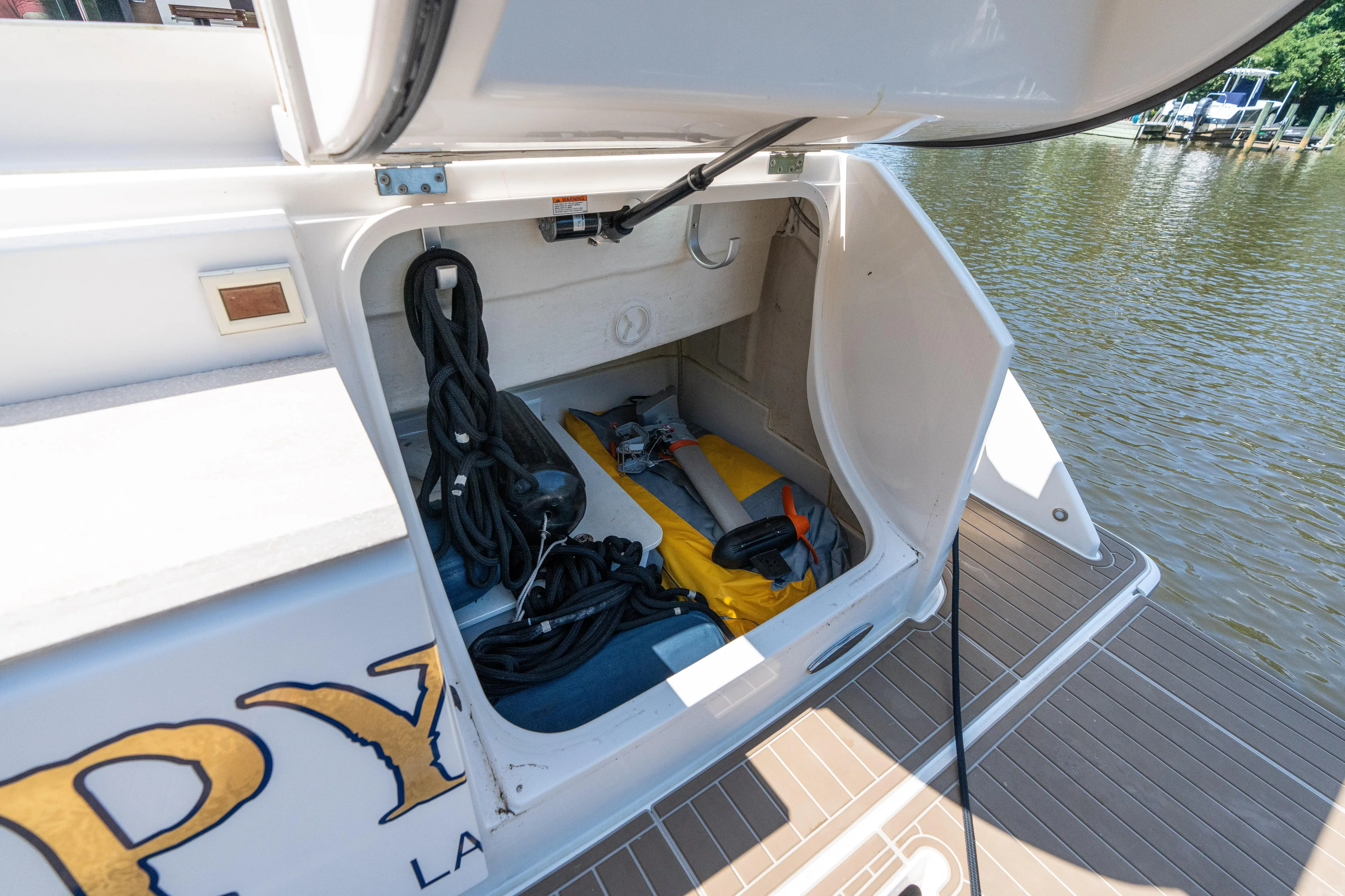 Pyrite Yacht Photos Pics Open storage compartment on 2015 Tiara Yachts C44 Coupe, docked by the water.