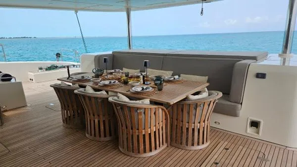 Little Giant Yacht Photos Pics Luxurious Sunreef 88 DD yacht deck with elegant dining setup, overlooking serene ocean views.