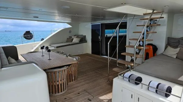 Little Giant Yacht Photos Pics Luxurious Sunreef 88 DD yacht interior with wooden deck, seating, and ocean view.