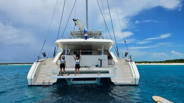 Little Giant Yacht Photos Pics Luxury Sunreef 88 DD yacht on clear blue water, 2017 model, with people enjoying the deck.