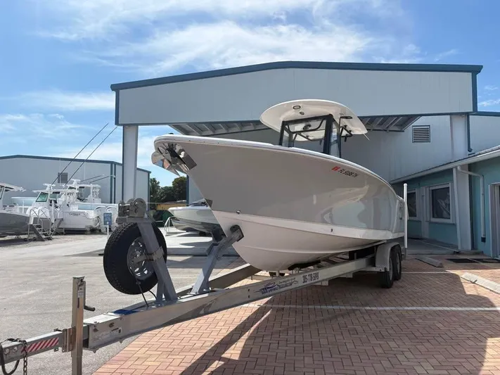  Yacht Photos Pics 2022 SeaHunter 275 ULTRA boat on trailer, parked outside a building under a clear sky.