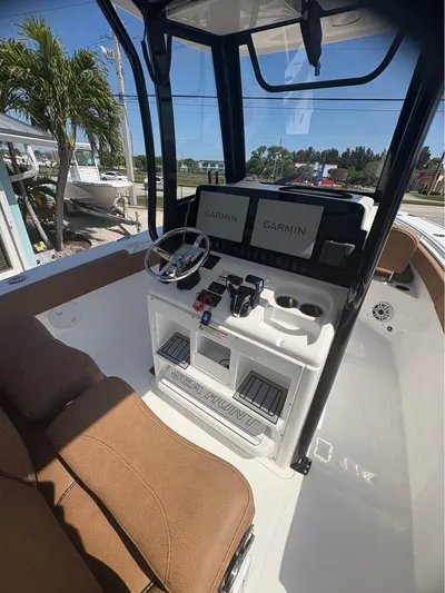  Yacht Photos Pics 2022 SeaHunter 275 ULTRA boat cockpit with Garmin navigation system and brown seating.
