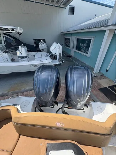  Yacht Photos Pics 2022 SeaHunter 275 ULTRA with dual outboard engines, docked near a blue building.