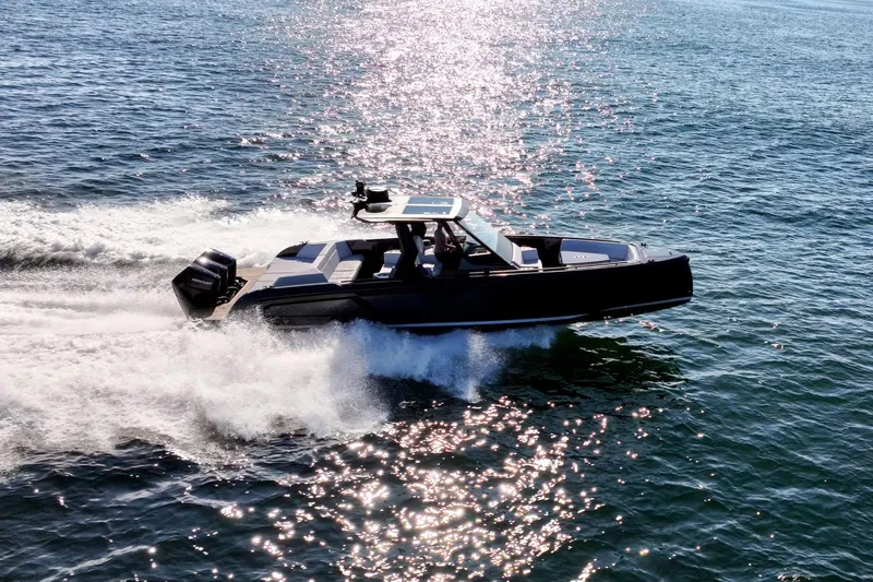  Yacht Photos Pics 2024 Vanquish Yachts 40 speeding on open water, reflecting sunlight.