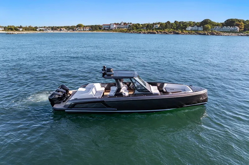  Yacht Photos Pics 2024 Vanquish Yachts 40 cruising on calm waters near a scenic coastline.