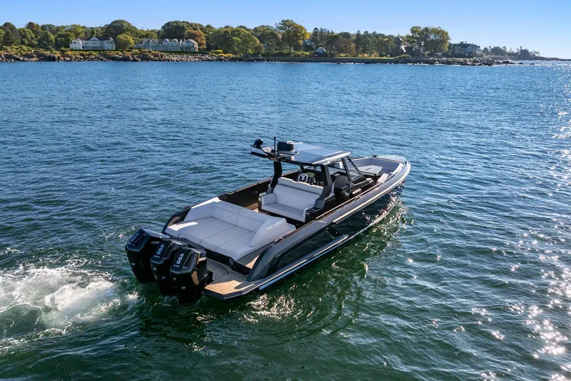  Yacht Photos Pics 2024 Vanquish Yachts 40 cruising on a sunny day near a scenic coastline.