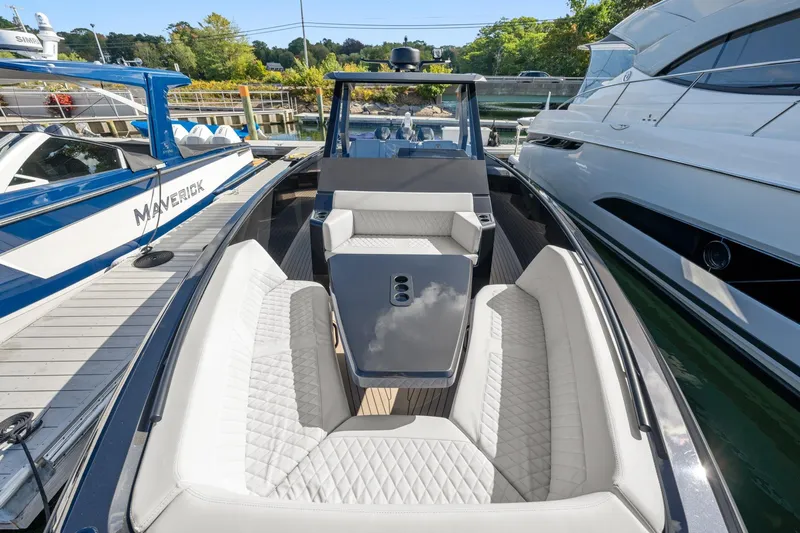  Yacht Photos Pics 2024 Vanquish Yachts 40 with luxurious seating, docked alongside other boats.