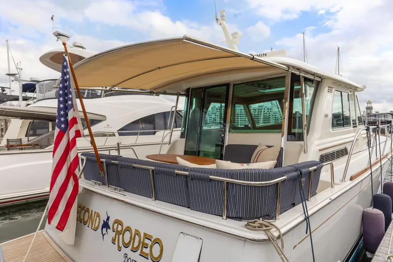 Second Rodeo Yacht Photos Pics 2018 Sabre 48 Salon Express yacht docked, featuring a rear deck with seating and an American flag.